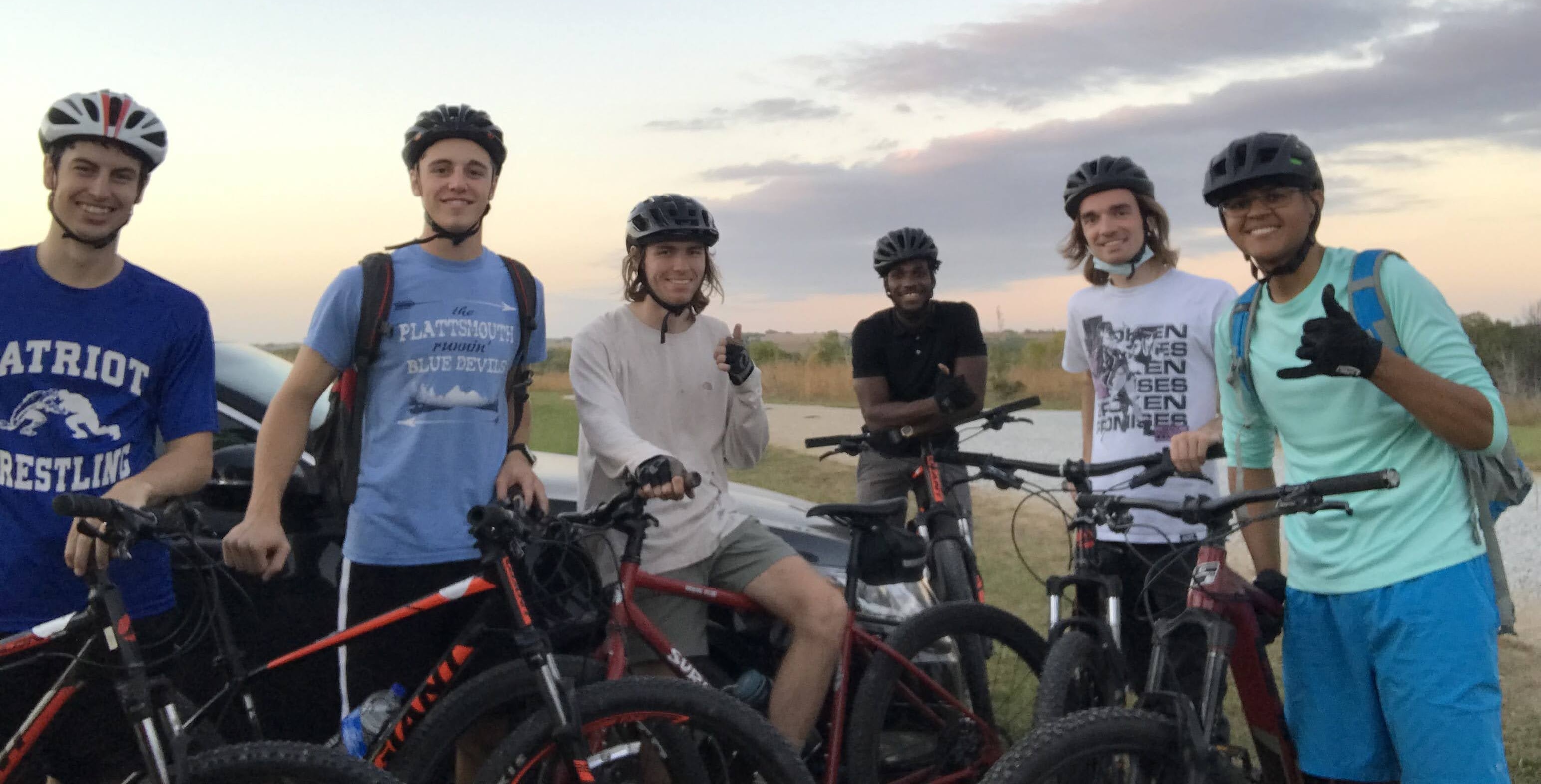 Six cyclists posing for a photo with their bikes