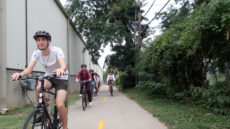 Cyclists in a line biking towards the camera on a Lincoln bike path